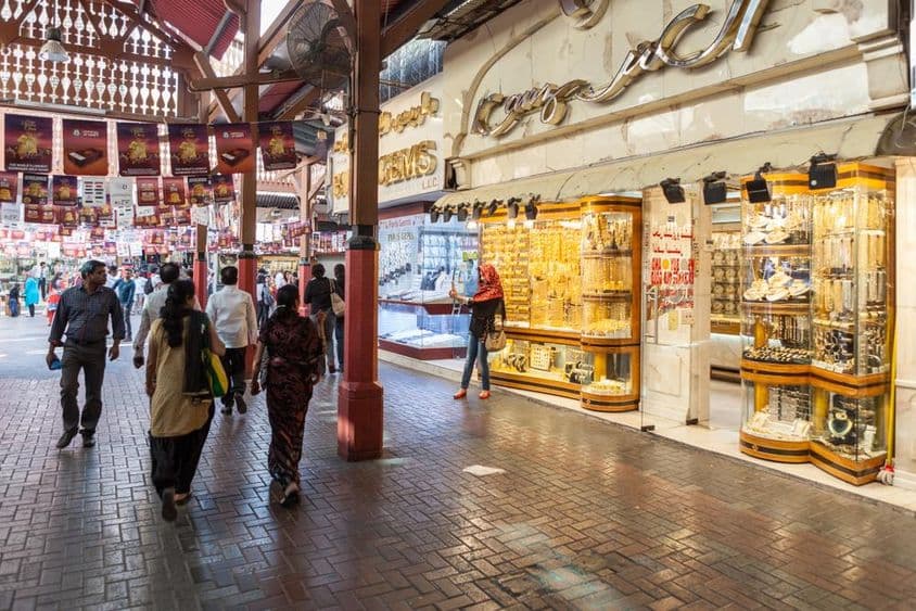 marché de l'or de Dubaï, une boutique exposant des bijoux en or, avec des passants.