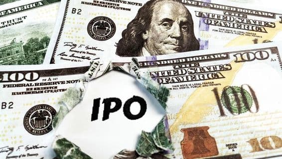Un morceau de papier avec 'IPO' posé sur des billets de 100 dollars américains.