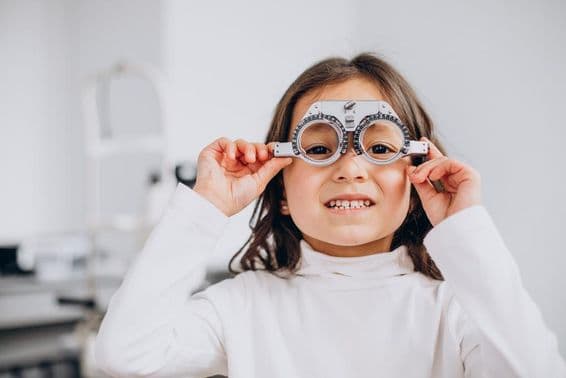 Jeune fille malvoyante portant des lunettes d'essai chez un opticien.