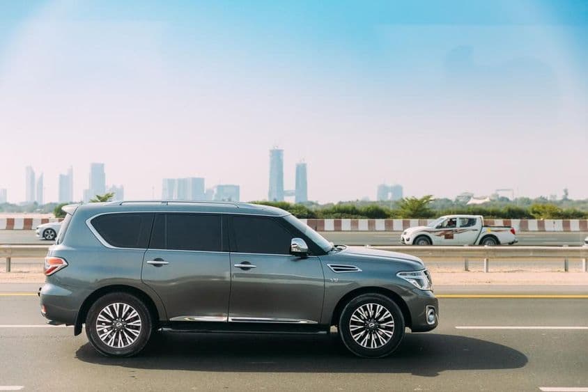 Nissan Patrol au premier plan avec gratte-ciels de Dubaï en arrière-plan.