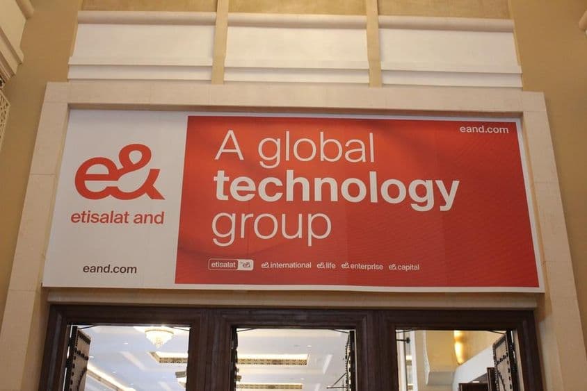 Publicité de la société Etisalat au-dessus d'une vitrine avec entrée en verre visible.