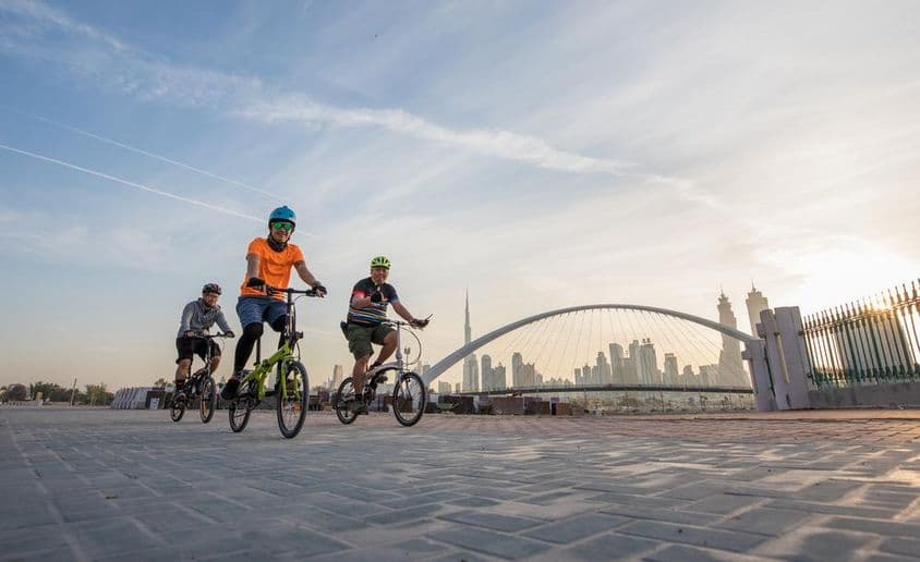 Cyclistes avec casques devant Burj Khalifa.