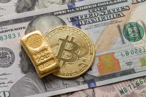 Un lingot d'or d'investissement et une pièce Bitcoin sur un billet de 100 dollars.