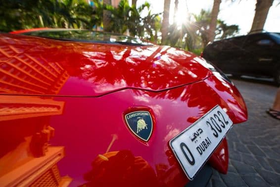 Une Lamborghini rouge vue de face, affichant une plaque d'immatriculation de quatre chiffres de Dubaï.