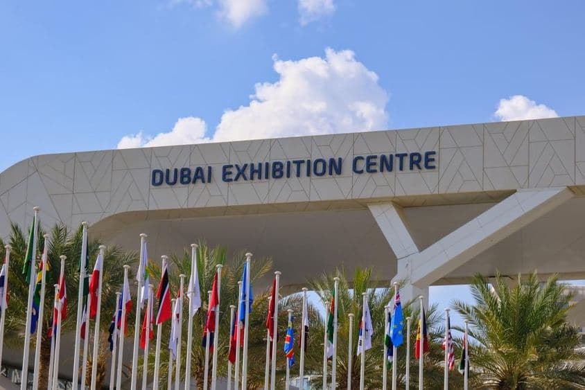 Centre d'Exposition de Dubaï avec des drapeaux au premier plan.