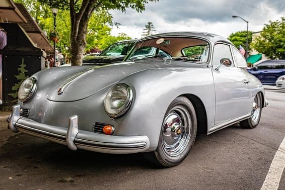 Une Porsche 356A est vue garée sous un arbre.