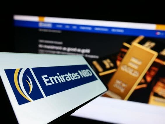 Signalétique Emirates NBD au premier plan, arrière-plan montrant un lingot d'or d'investissement.