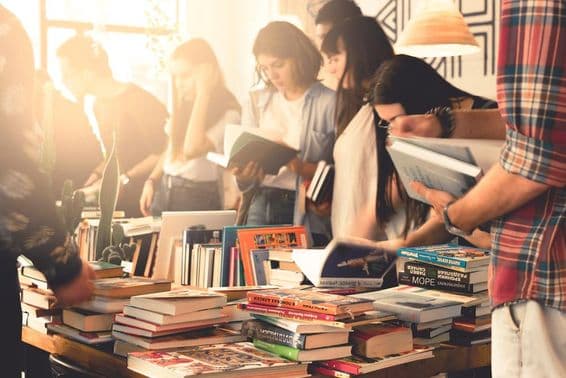 Des étudiants feuilletant des livres lors d'un grand salon.