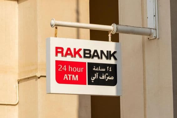 Enseigne d'un distributeur automatique RAKBANK en texte rouge et partiellement noir.