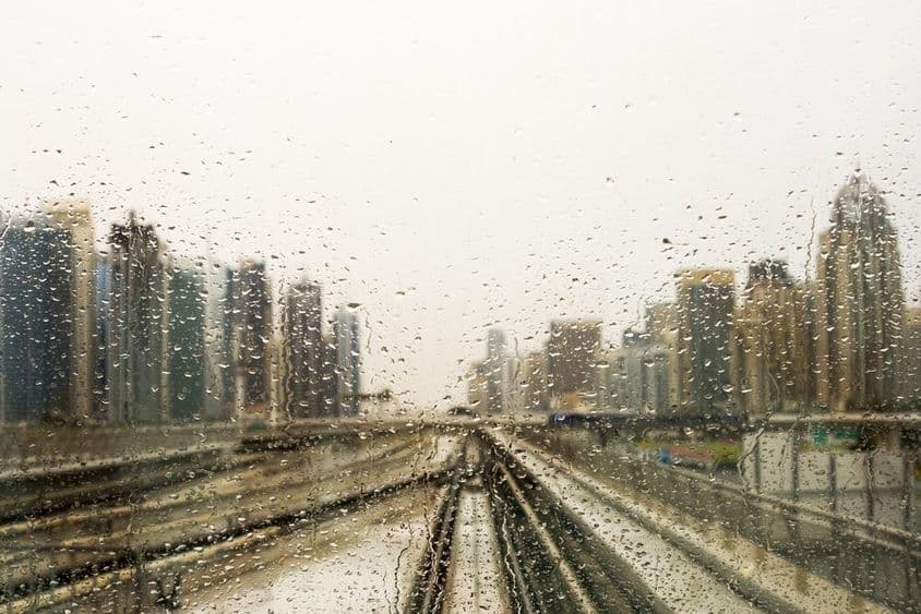 Fenêtre trempée de pluie avec vue de gratte-ciel.