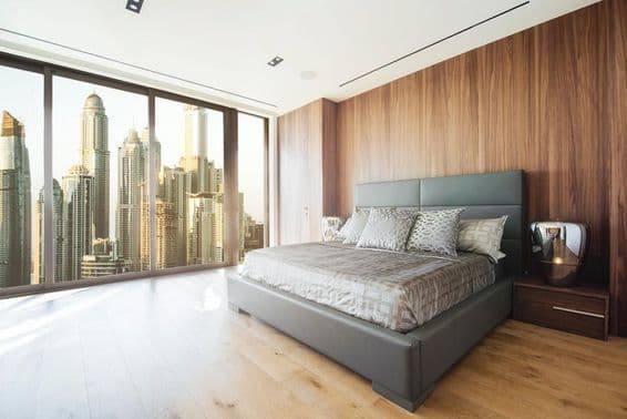 Intérieur d'une chambre à Dubaï avec vue sur des gratte-ciel.