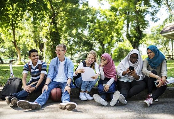 Étudiants à Dubaï assis sur un trottoir.