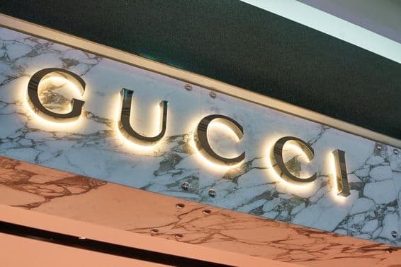 Enseigne Gucci en lettres lumineuses sur une façade murale.