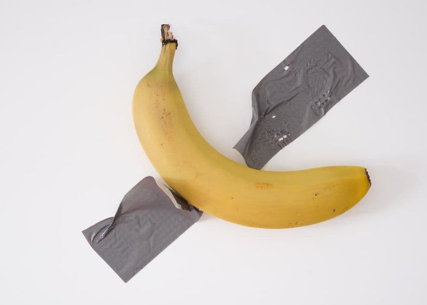 Une banane scotchée au mur avec du ruban adhésif gris.