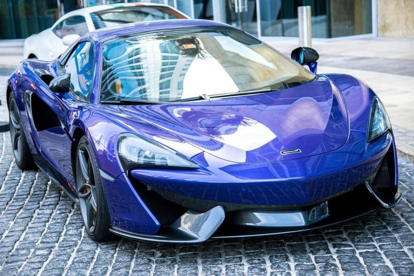 Voiture McLaren bleue garée dans une rue de Dubaï.