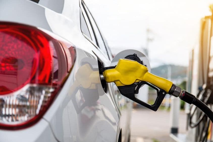 Pistolet de ravitaillement inséré dans l'ouverture de remplissage d'une voiture.