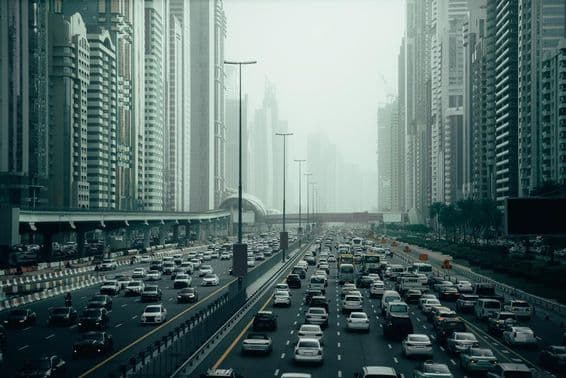 Autoroute bondée de Dubaï en ville, 2x7 voies, gratte-ciel de chaque côté.
