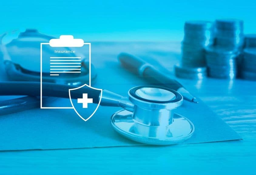 Assurance santé en avant-plan, arrière-plan avec un stéthoscope et de la petite monnaie.