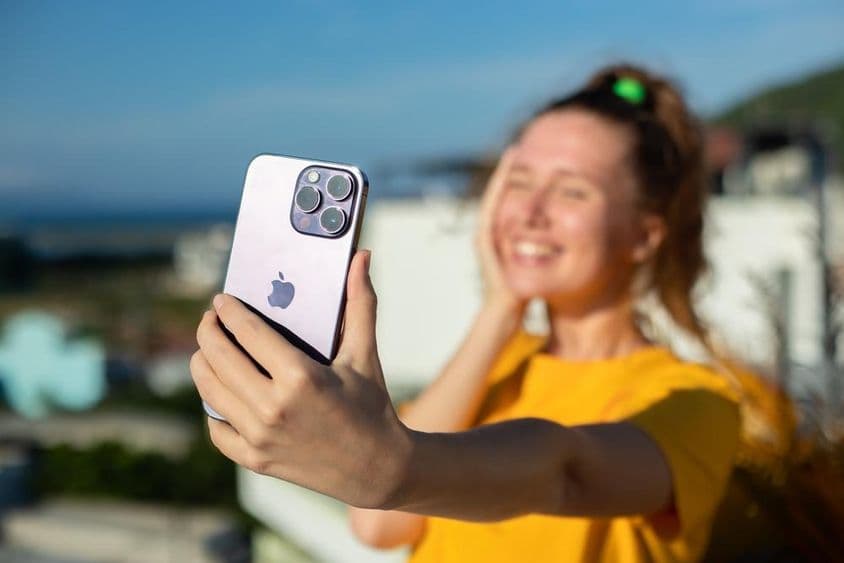 Jeune fille tenant un téléphone iPhone.