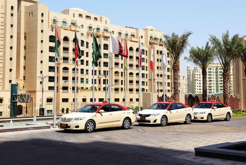 Taxis de Dubaï devant un bâtiment résidentiel de 10 étages.