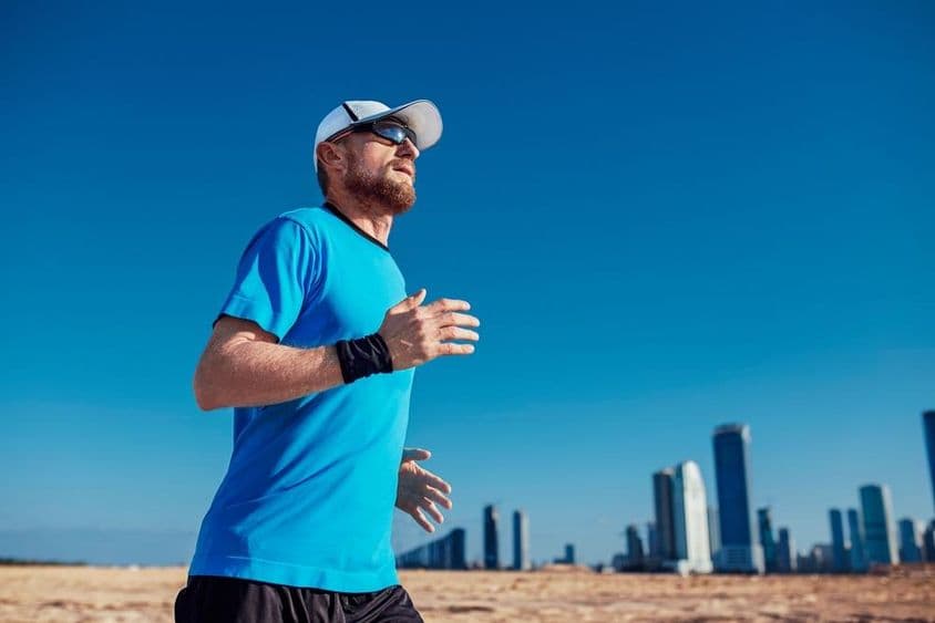Triathlon de Dubaï, un homme courant avec des gratte-ciels en arrière-plan.