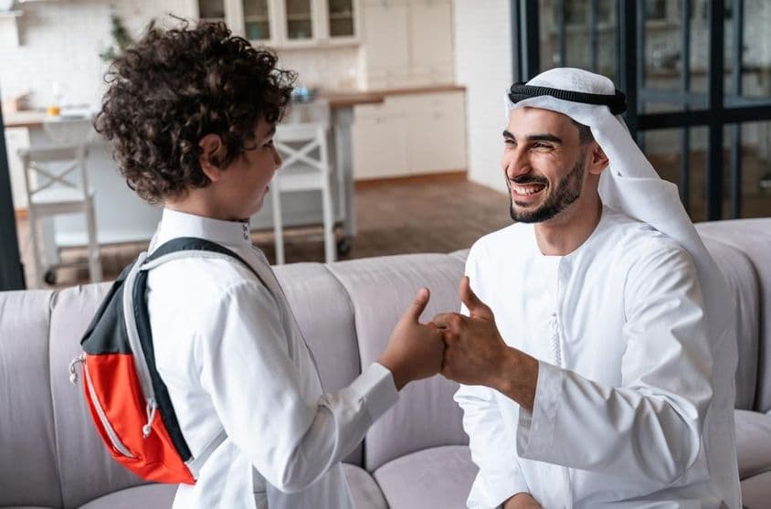 Un père et un fils arabes se préparant pour l'école.