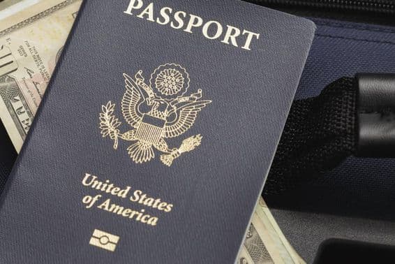 Passeport américain posé sur des dollars.