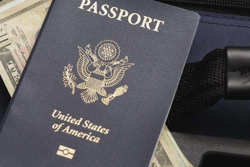 Passeport américain posé sur des dollars.