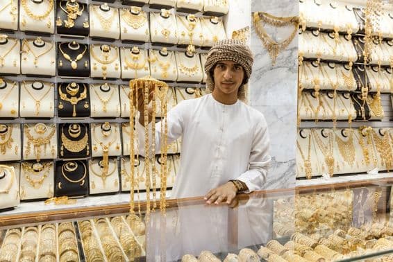 Garçon arabe présente de l'or dans un magasin.
