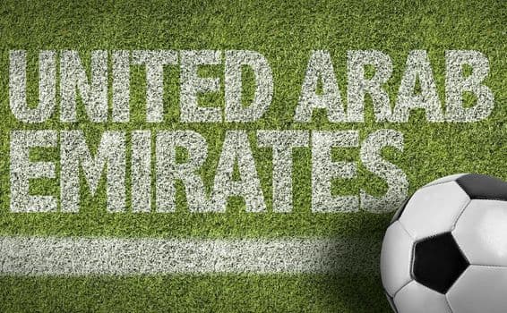 Inscription UAE peinte sur l'herbe avec un ballon de football.