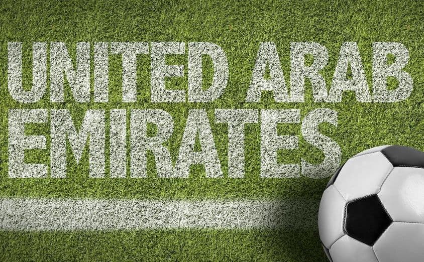 Inscription UAE peinte sur l'herbe avec un ballon de football.