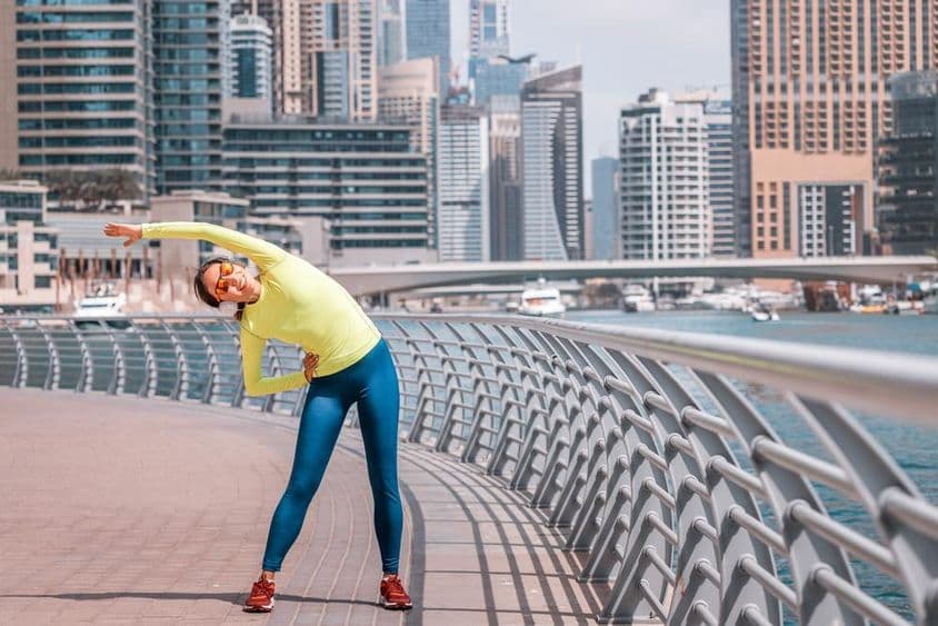 Jeune fille à Dubaï s'étirant après une course à la Marina.