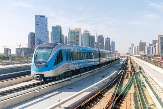 Train de métro Dubai avec des bâtiments en arrière-plan.