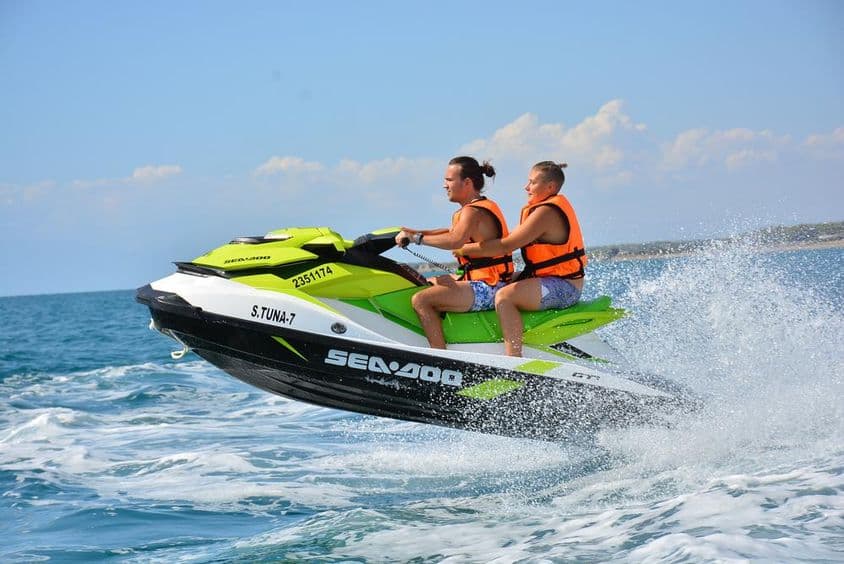 Jeune couple assis sur un jet ski.