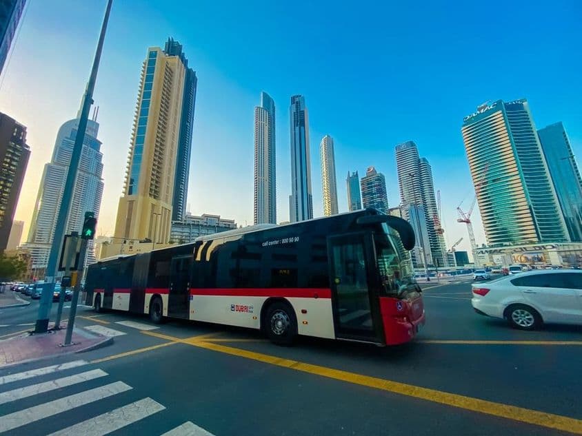Bus de Dubaï avec gratte-ciel en arrière-plan.