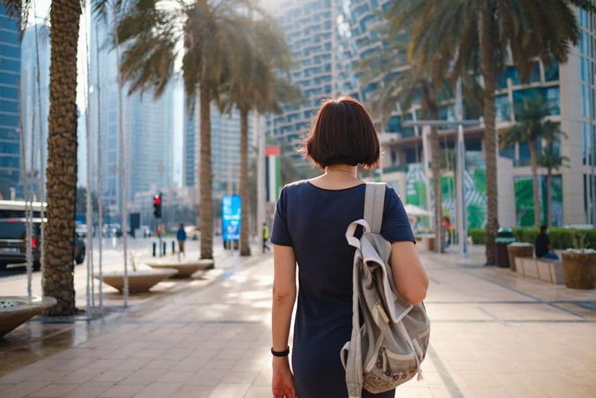 Femme marchant à Dubaï avec un sac à dos.