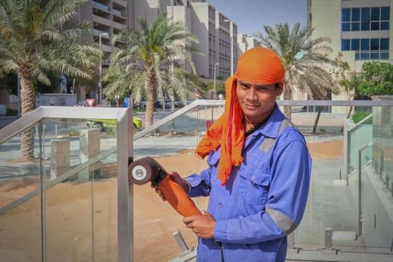 Ouvrier à Dubaï polissant une rampe.