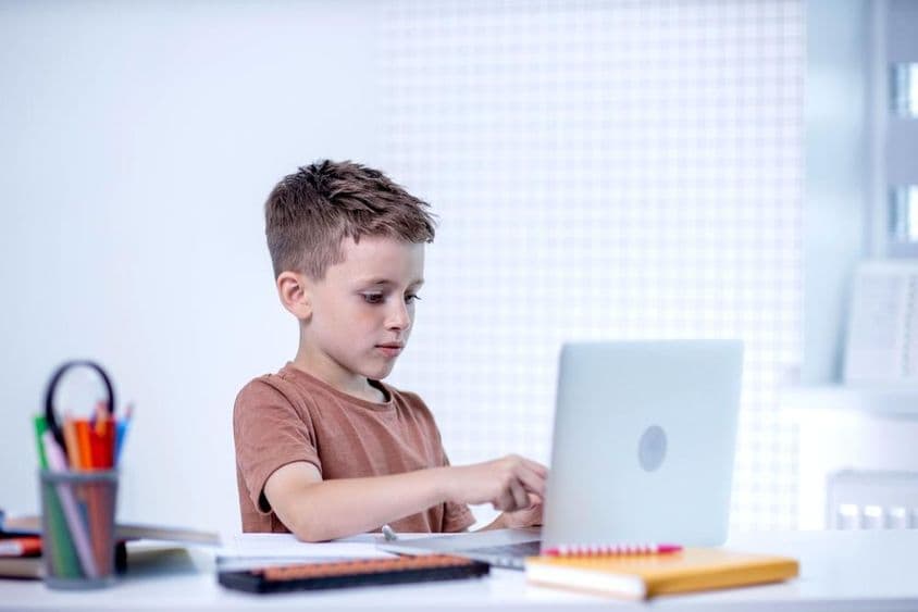 Écolier apprenant avec un ordinateur.