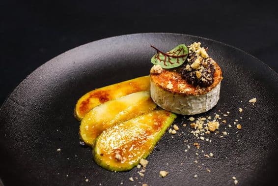 Fromage de chèvre grillé avec poire caramélisée présenté style gastronomie fine