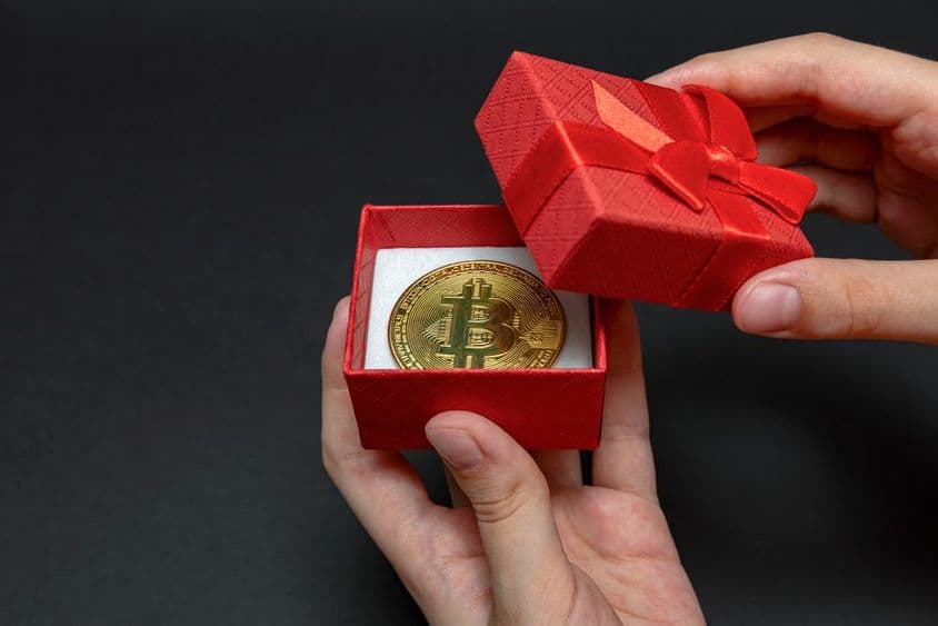 Pièce de Bitcoin dans une boîte cadeau.
