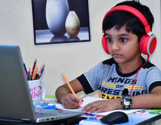 Enfant d'école à Sharjah écrivant une leçon.