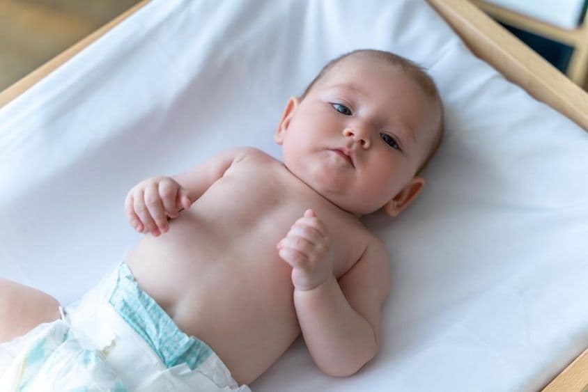 Bébé blanc allongé en couche.