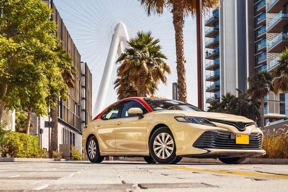 Taxi à Dubaï avec une grande roue en arrière-plan.
