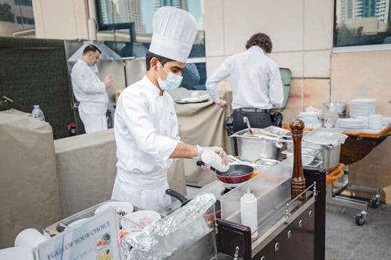 Chef faisant frire un œuf dans une cuisine.