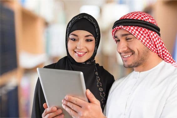 Étudiants en arabe regardant du matériel d'étude sur une tablette.