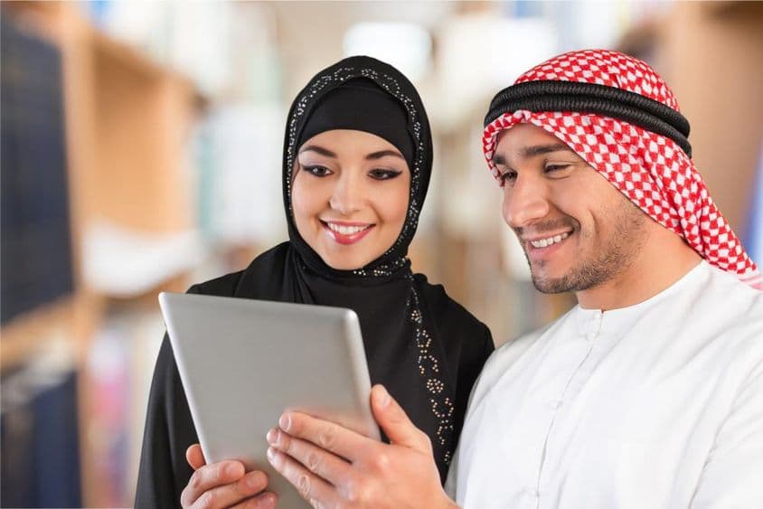 Étudiants en arabe regardant du matériel d'étude sur une tablette.