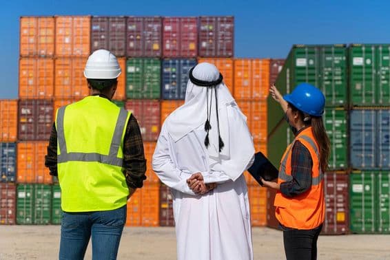 Homme d'affaires du Moyen-Orient et ingénieurs travaillant à l'extérieur d'un grand quai commercial.