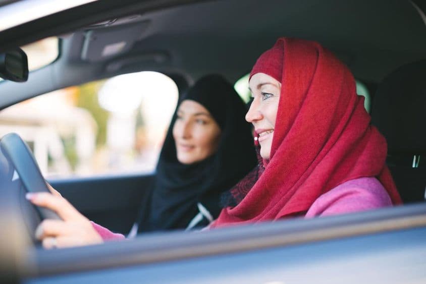 Femme musulmane au volant, transportant une autre femme musulmane.