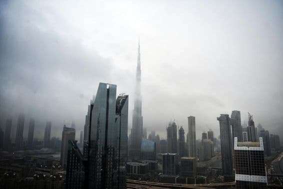 Ligne d'horizon de Dubaï avec des bâtiments enveloppés de nuages.
