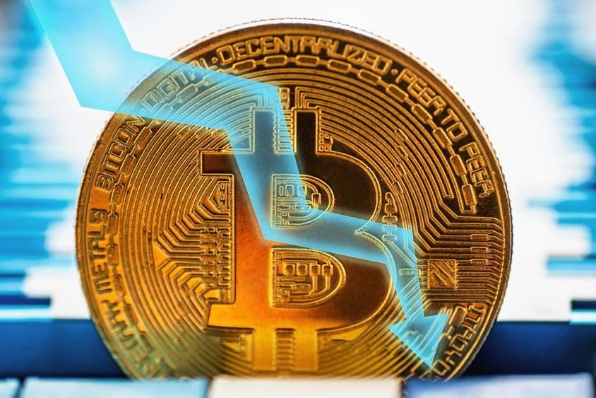 Pièce de Bitcoin dorée - symbole de cryptomonnaie et flèche pointant vers le bas sur fond technique.